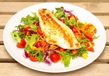 Kızarmış balık filetosu, tabakta salata