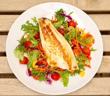 Kızarmış balık filetosu, tabakta salata