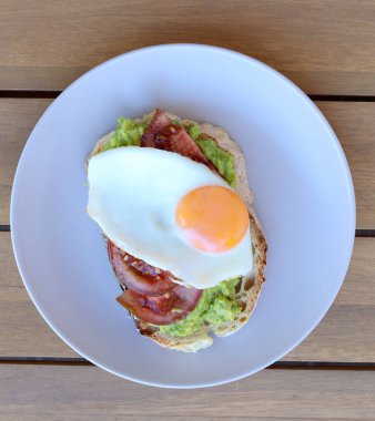 Yağda yumurta, avokado ve domatesli sandviç.