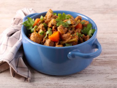 Yeşil fasulyeli biftek güveci ve mavi kabın içinde havuç.