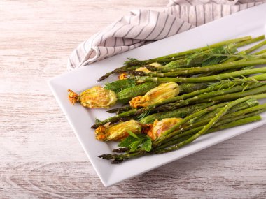 Pişmiş kuşkonmaz ve içi doldurulmuş çiçekli mini kabak.