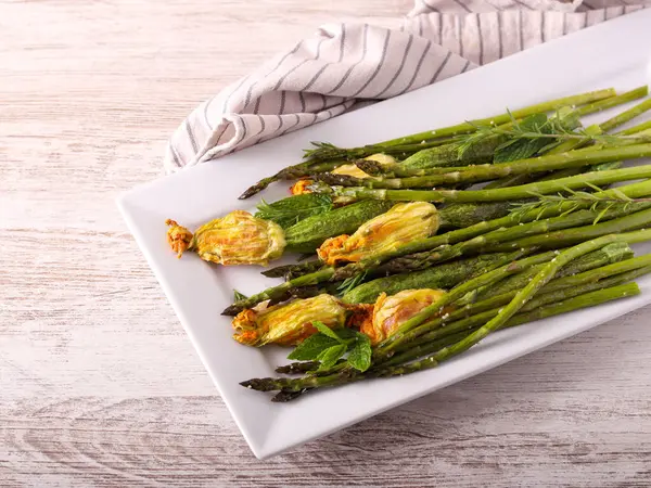 Pişmiş kuşkonmaz ve içi doldurulmuş çiçekli mini kabak.