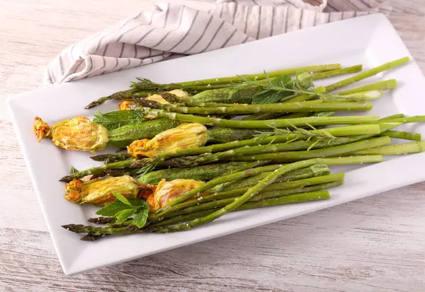 Pişmiş kuşkonmaz ve içi doldurulmuş çiçekli mini kabak.