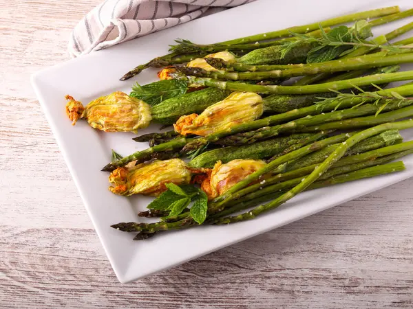 Pişmiş kuşkonmaz ve içi doldurulmuş çiçekli mini kabak.