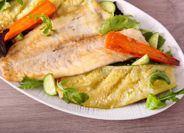Pişmiş beyaz balık fileto ve sebze.
