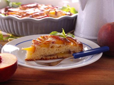 Ev yapımı şeftalili kek, tabakta dilimlenmiş.