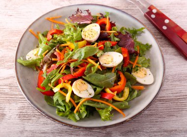 Taze sebze ve bıldırcın yumurtası tabakta.