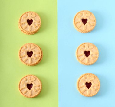 Jam filled sandwich cookies over colored background