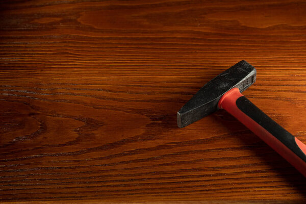 Молоток на деревянном столе крупным планом. Ручной инструмент для ремонта чего-то в доме. Свободное место для текста.