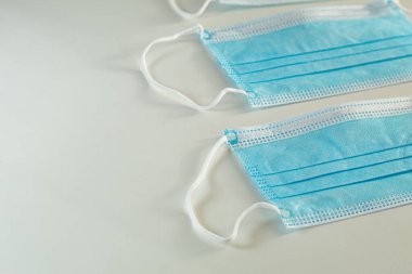 Beyaz arka planda tek kullanımlık maske, yakın plan, tıbbi geçmiş. Metin için boşluk.