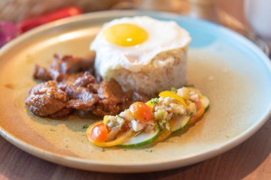 Pirinçli sahanda yumurta ve kızarmış domuz etinin yüksek açılı yakın çekimi.