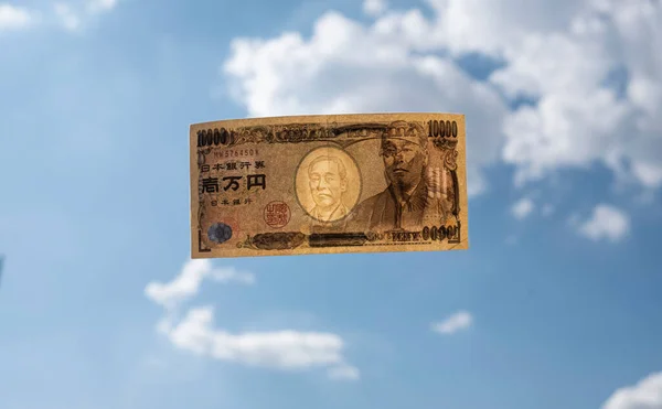日本の1万円紙幣は 雲のある青空の上に書かれている お金のコンセプトの損失 お金の飛行 — ストック写真