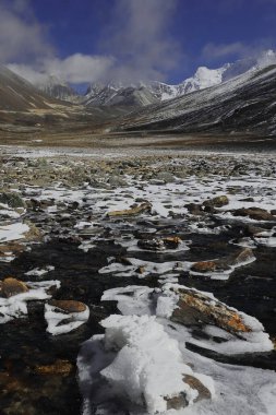 Manzara manzarası, donmuş karla kaplı vadide akan güzel dağ akıntısı sıfır noktasında Himalaya karları ile çevrili ya da Kuzey Sikkim, Hindistan 'daki Yumesodong vadisi