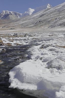 Manzara manzarası, donmuş karla kaplı vadide akan güzel dağ akıntısı sıfır noktasında Himalaya karları ile çevrili ya da Kuzey Sikkim, Hindistan 'daki Yumesodong vadisi