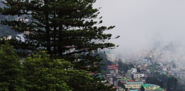 Muson mevsiminde bulutlar güzel Darjeeling tepe istasyonunda süzülüyor, panoramik kasaba manzarası ve himalaya dağ etekleri, Hindistan