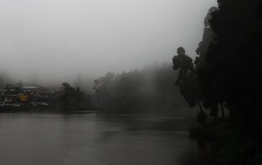 Muson mevsiminde Mirik Hill İstasyonu 'ndaki karanlık çam ormanı ve gölü, Hindistan' ın batısındaki Himalaya eteklerini sis ve sis kapladı.