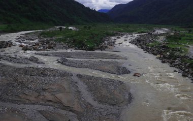 Dağ nehir balonu, Hindistan 'ın Darjeeling bölgesindeki Dudhia yakınlarındaki Himalaya eteklerindeki yemyeşil vadiden geçiyor.
