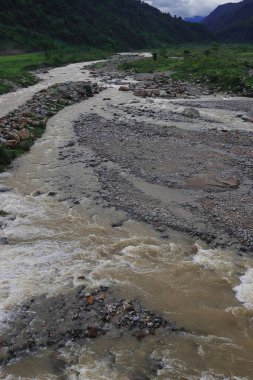 Dağ nehir balonu, Hindistan 'ın Darjeeling bölgesindeki Dudhia yakınlarındaki Himalaya eteklerindeki yemyeşil vadiden geçiyor.