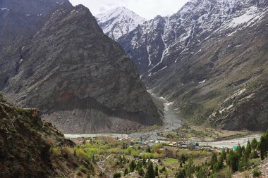 Manzaralı Jispa köyü, karla kaplı himalaya dağları ve Hindistan 'ın Himachal Pradesh kentindeki Lahaul bölgesindeki yemyeşil Bhaga Nehri vadisi.