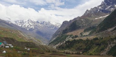 Karla kaplı Himalaya dağlarıyla çevrili güzel vadinin panoraması, dağ köyü ve tarım arazisi kuşları, Hindistan 'ın Himachal Pradesh kentindeki lahaul ve spiti manzarası