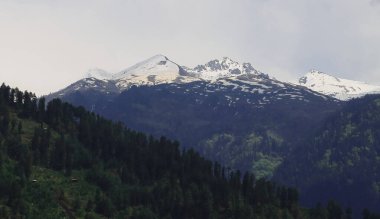 Manali yakınlarındaki manzaralı dağ manzarası ve sakin kırsal bölge, Hindistan 'ın Himachal Pradesh kentindeki kullu vadiden karla kaplı Himalayalar.