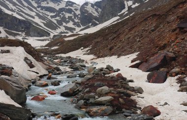 Dağ deresi, Himalaya dağlarıyla çevrili donmuş Alp Vadisi 'nden akıyor. Rohtang geçidi yakınlarındaki Marhi' de. Manali, Himachal Pradesh, Hindistan.