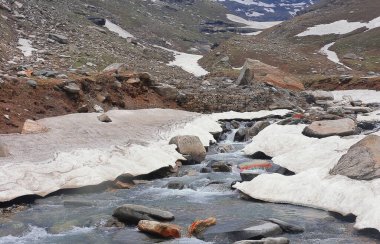Dağ deresi, Himalaya dağlarıyla çevrili donmuş Alp Vadisi 'nden akıyor. Rohtang geçidi yakınlarındaki Marhi' de. Manali, Himachal Pradesh, Hindistan.