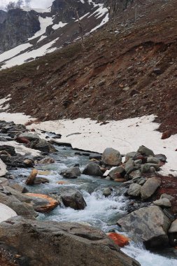 Dağ deresi, Himalaya dağlarıyla çevrili donmuş Alp Vadisi 'nden akıyor. Rohtang geçidi yakınlarındaki Marhi' de. Manali, Himachal Pradesh, Hindistan.