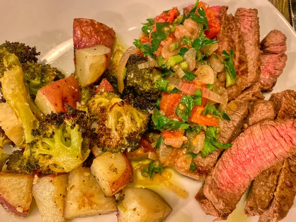 seared beef steak, baked potatoes and vegetable salad - image