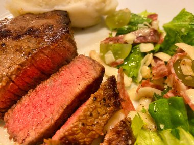 Orta pişmiş biftek, patates püresi ve salata.