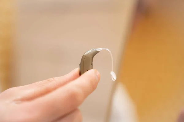 Hand of a doctor holding a hearing aid.