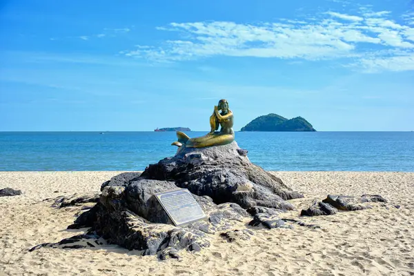Samila Sahili 'nde bulunan Songkhla deniz kızı heykeli, arka planda küçük bir ada bulunan bir kayanın üzerinde oturuyor.