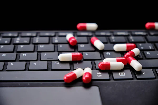 Bir bilgisayar klavyesinin üstündeki beyaz ve kırmızı kapsüllerin yakın plan görüntüsü.