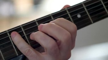 Rock 'n roll gitarının notalarını çalan bir adamın yakın çekimi..