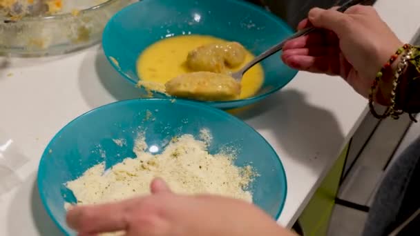 女性の手の近くにいくつかの自家製コロッケを調理 卵とパン粉でそれらを浸します — ストック動画