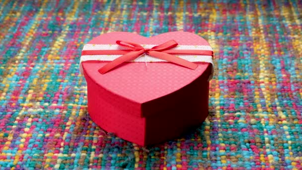赤いハート型の箱のクローズアップは 女性が箱を開けてお金でいっぱいであることを発見します バレンタインデー — ストック動画