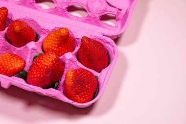 Pink Egg Carton with Fresh Strawberries on a Pastel Pink Background