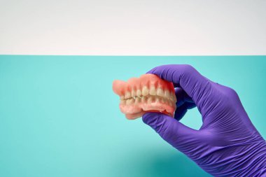 Bir atölyede el yapımı diş protezi yapan diş teknisyeni.