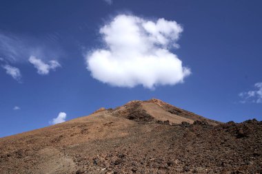 Teide zirvesi, mavi bir gökyüzü ve beyaz bir bulut.