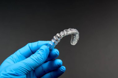 Elinde mavi eldiven takan biri temiz bir desteğe sahip. Görüntü, jest, parmak, müzik aleti gibi kavramları anımsatabilir.