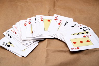 Karton gibi bir yüzeye yayılmış poker kartlarının karıştırılması.