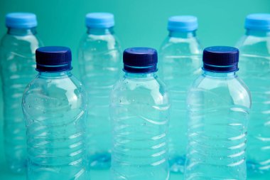 Birkaç plastik şişe yeşil arka planda geri dönüşüme hazır..