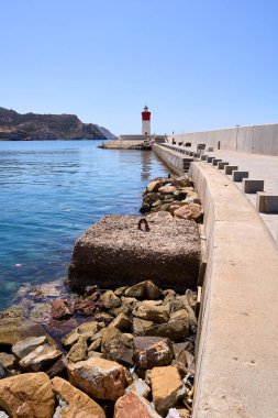 Red and white lighthouse in the Mediterranean Sea in Cartagena, Murcia. clipart