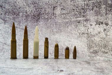 Various types of ammunition for different weapons arranged in a row. clipart