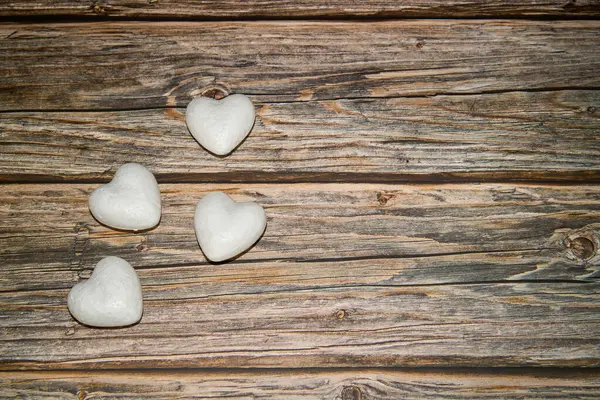 Yukarıdaki beyaz mantar parçalarından, kalp şeklinde, ışıktaki ahşap bir yüzeye yerleştirilmiş.