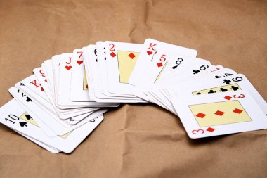 Karton gibi bir yüzeye yayılmış poker kartlarının karıştırılması.