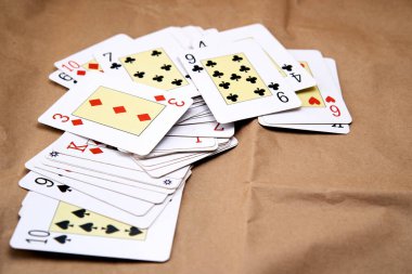 Karton gibi bir yüzeye yayılmış poker kartlarının karıştırılması.
