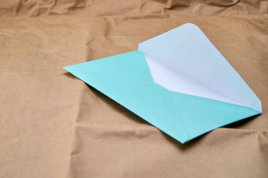 Karton desenli bir yüzeyde mavi bir zarf.