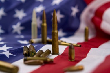 Mühimmat kartuşuna yakın çekim ve bir diğeri de Birleşik Devletler Bayrağı 'nın tepesinde odaksız..