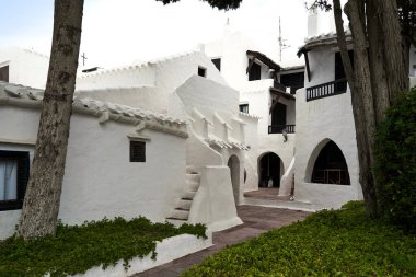 Menorca 'daki Binibeca' da doğal çevreyle güzel bir şekilde harmanlanmış kemer ve merdivenleri olan büyüleyici beyaz binalar bulunuyor..